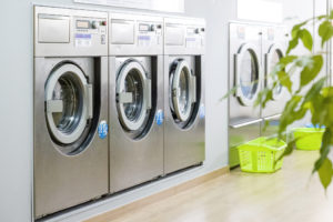 Public laundry with modern, silver washing machines in a row